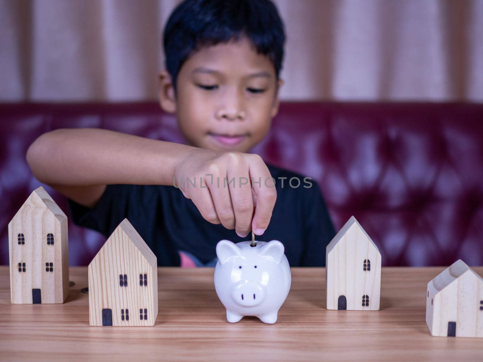 Boy saving money in a white pig piggy bank.Saving concept. Saving for the future.