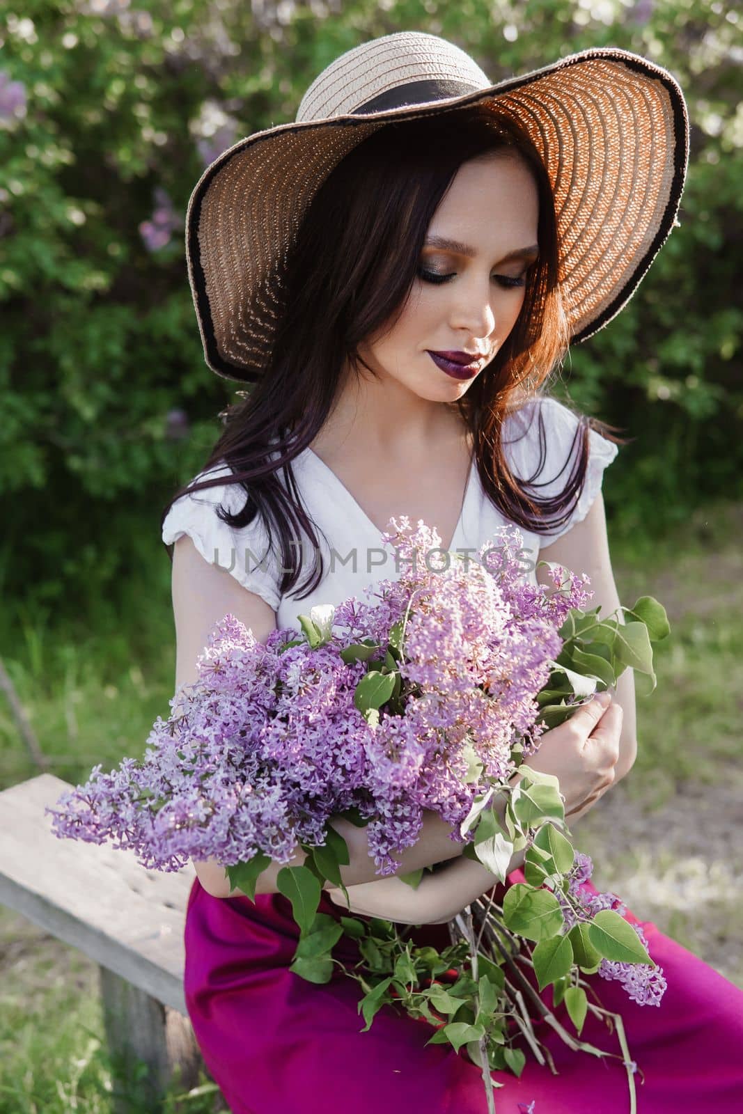 A fashionable girl with dark hair, a spring portrait in lilac tones in summer. Bright professional makeup