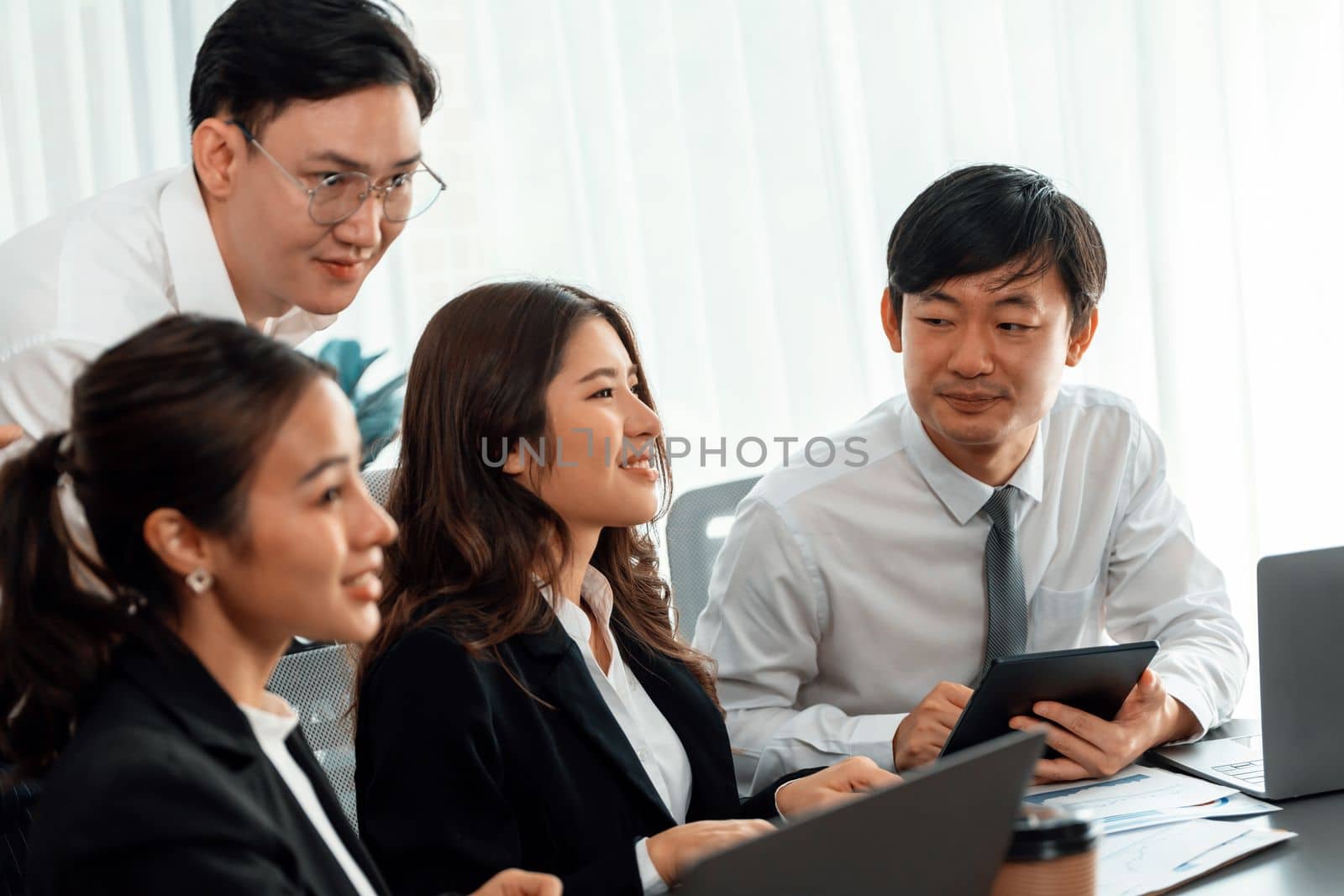 Harmony in office concept as business people analyzing dashboard paper together in workplace. Young colleagues give ideas at manager desk for discussion or strategy planning about project.