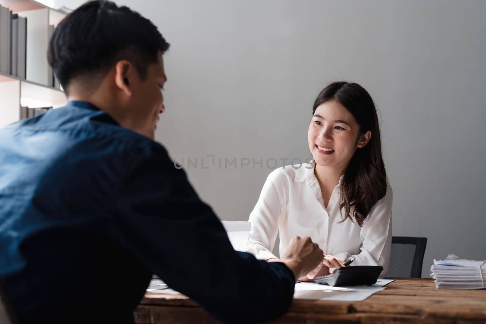 Businesswoman holding pens and holding graph paper are meeting to plan sales to meet targets set in next year... by wichayada