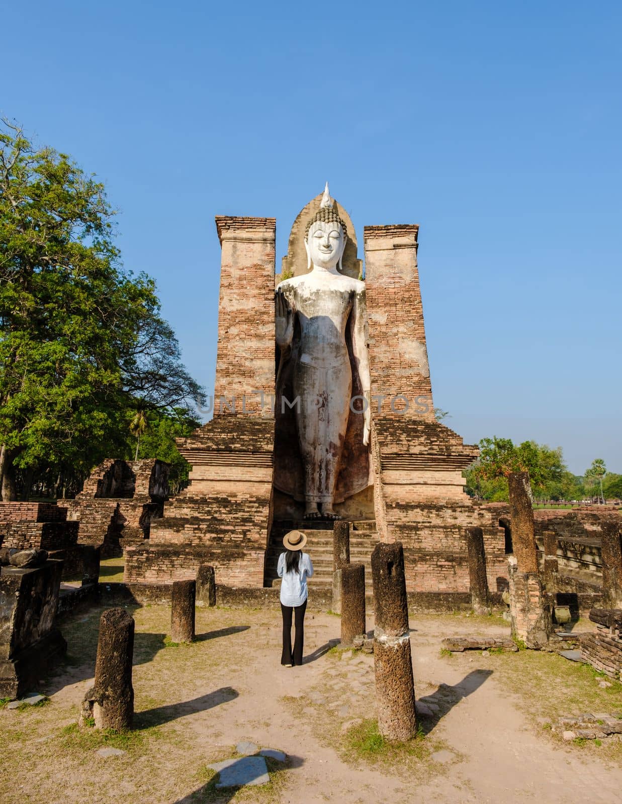 Asian women with a hat visit Wat Mahathat, Sukhothai old city, Thailand. Ancient city and culture of south Asia Thailand, Sukothai historical park