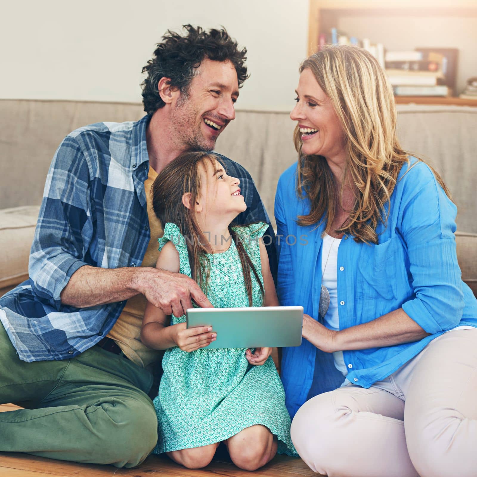 Learning about technology is a family experience. a happy family using a digital tablet together at home. by YuriArcurs