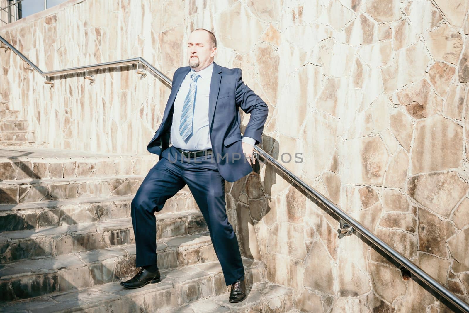 Portrait of a senior professional man in a suit with various problems. A middle-aged businessman with a briefcase descends the stairs.