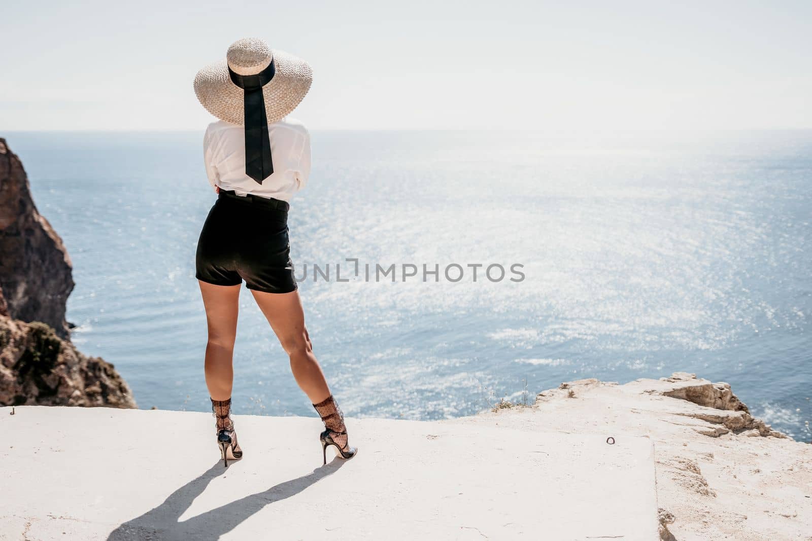 Woman sea hat. Business woman in yellow hat freelancer working over blue sea beach. Girl relieves stress from work. Freelance, digital nomad, travel and holidays concept by panophotograph