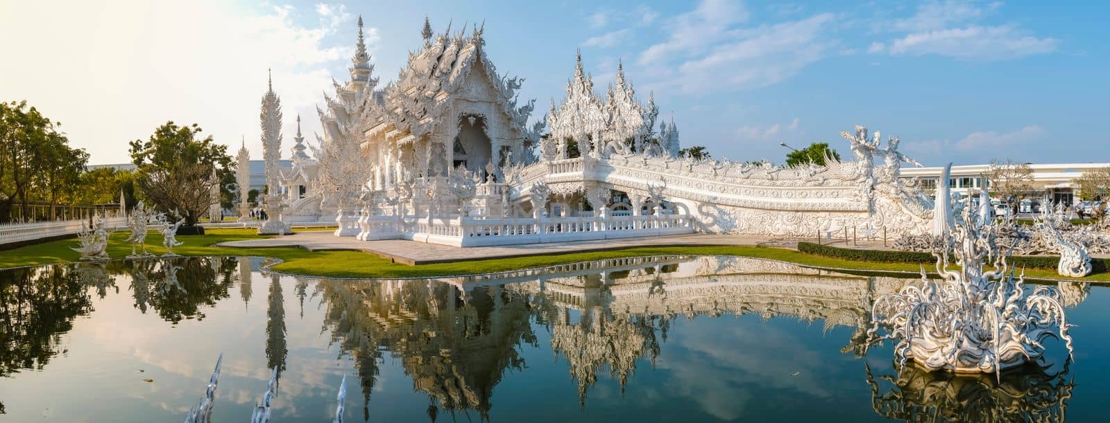 White temple Chiang Rai Thailand, Wat Rong Khun, aka The White Temple, in Chiang Rai, Thailand with a blue sky and reflection in the lake