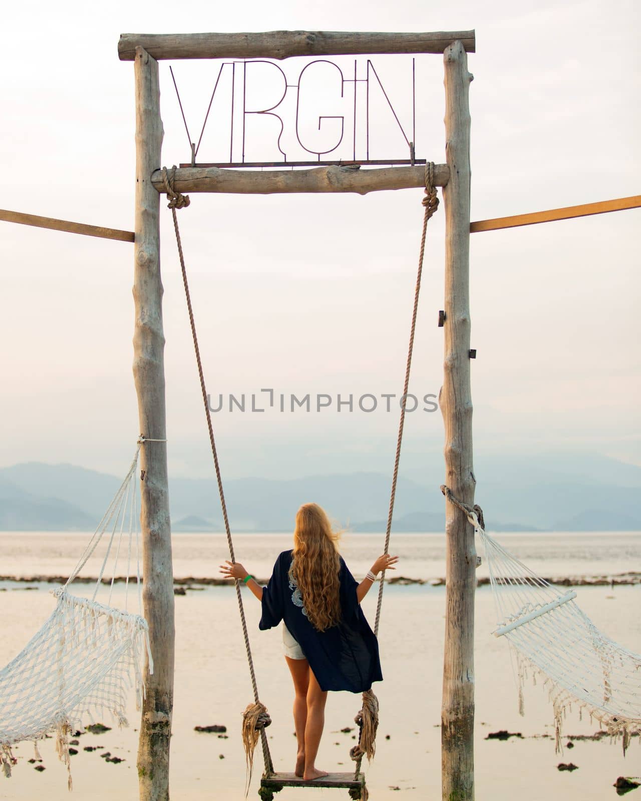 girl on a swing overlooking the sea by Alexzhilkin