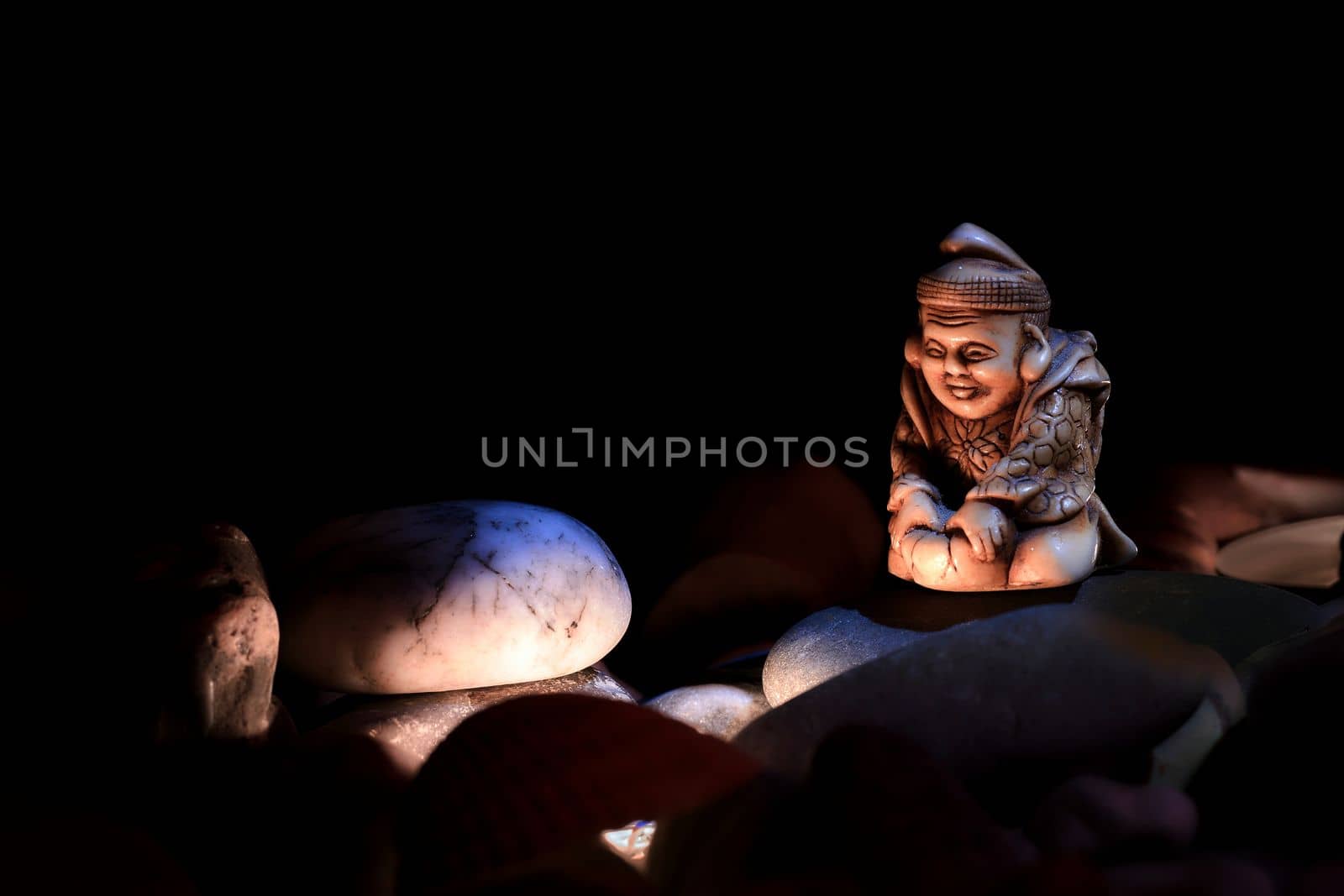 A serene calm monk meditates by the fire in darkness of the night among stones by jovani68