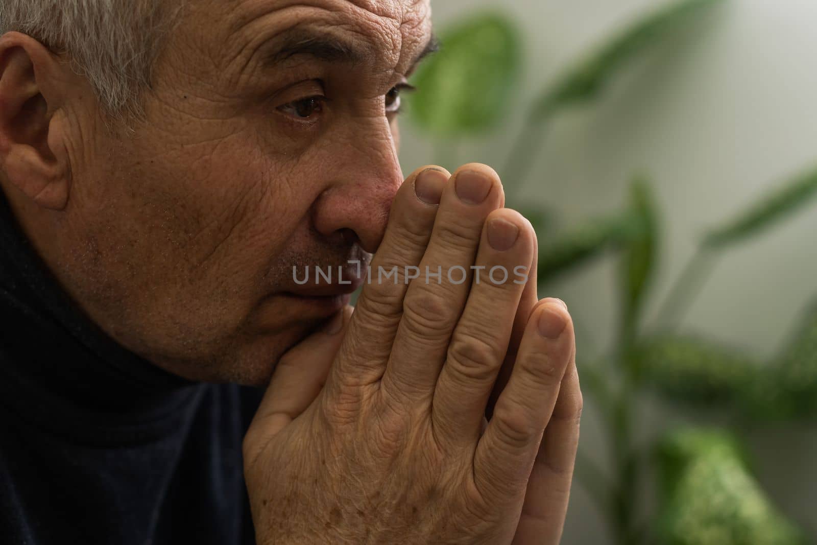 Elderly caucasian man with interlocked fingers.