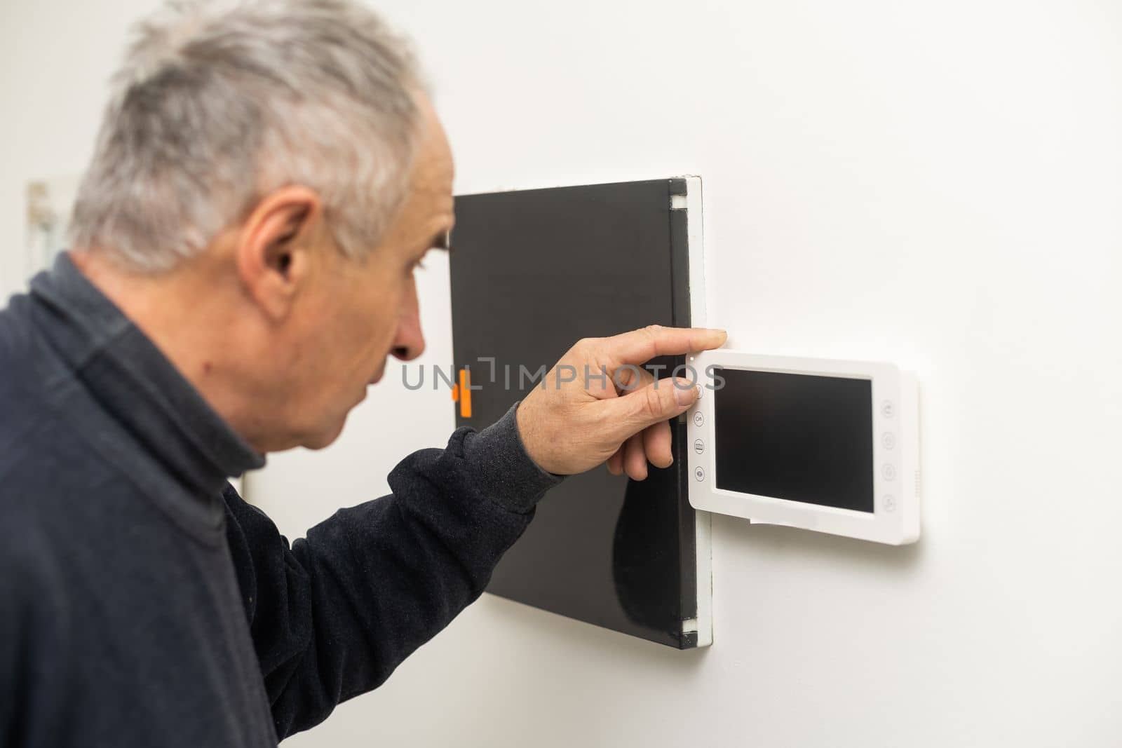 A worker repairs the intercom. Indoor intercom. by Andelov13