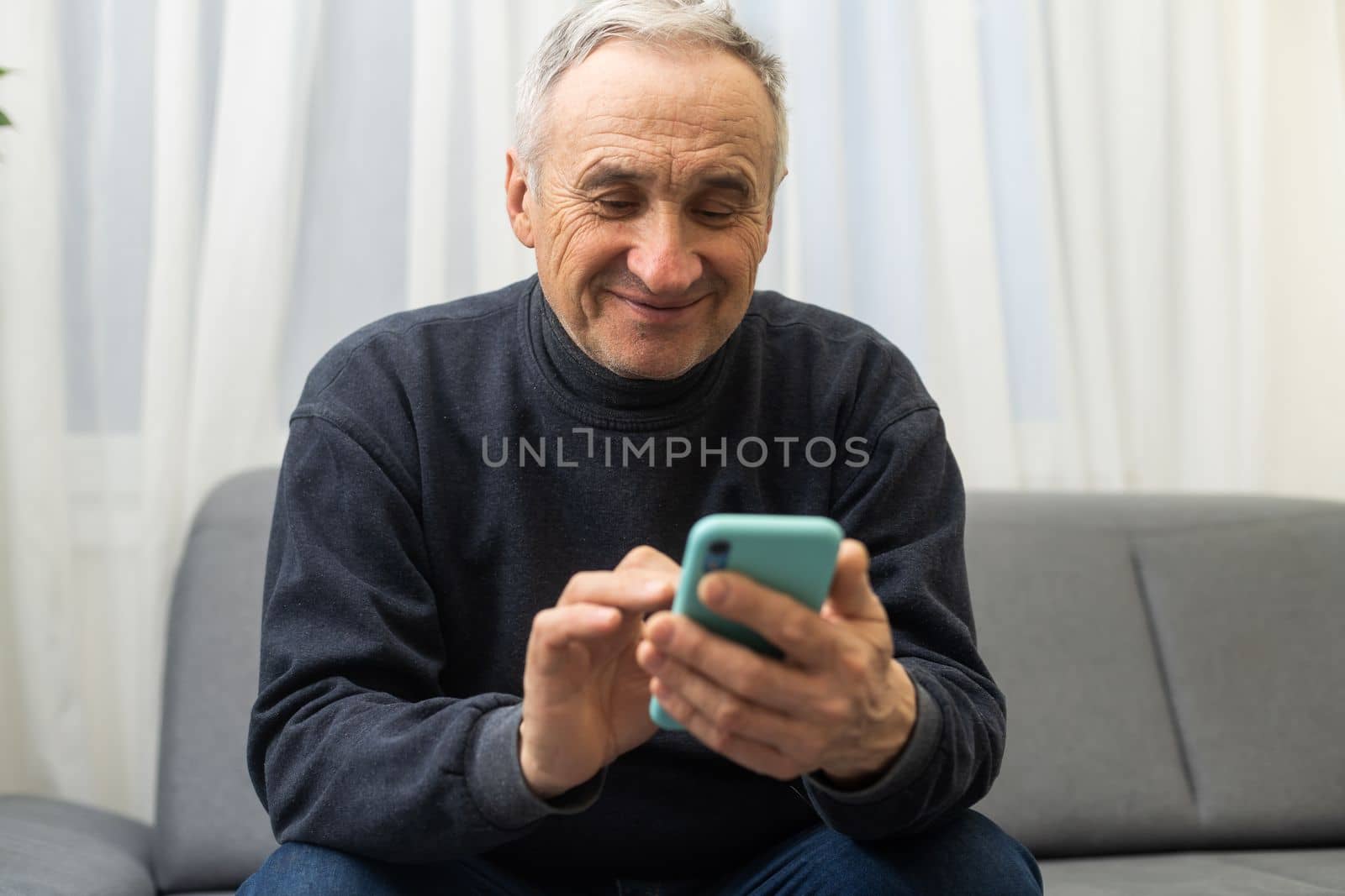 Elderly man using smartphone, mobile phone in male hands close up. Concept of online communication in retirement, sms, social media. by Andelov13