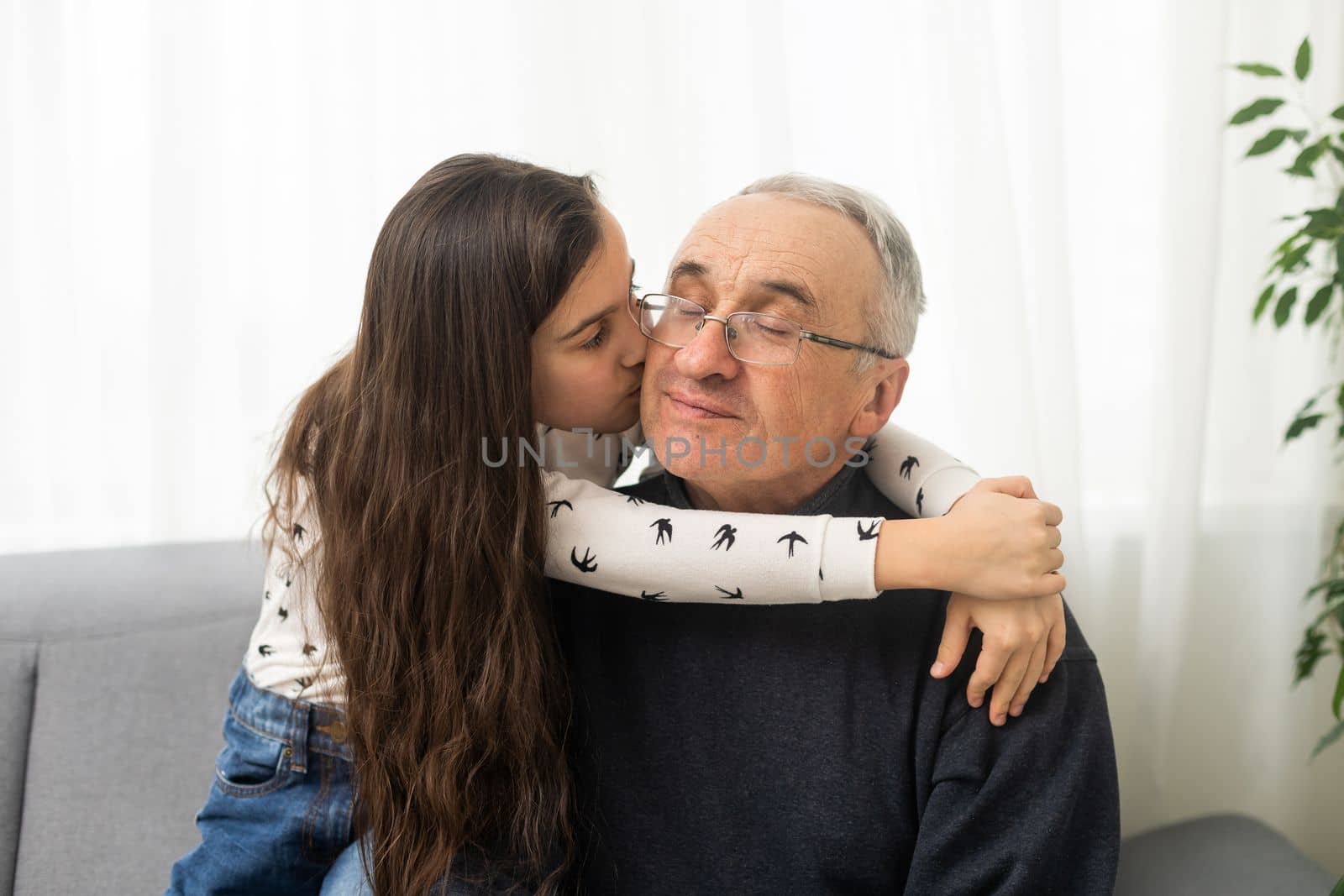 Little granddaughter hugging her grandfather.