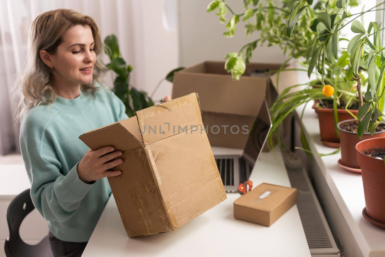 Closeup view of female online store small business owner seller entrepreneur packing package post shipping box preparing delivery parcel on table. Ecommerce dropshipping shipment service concept.