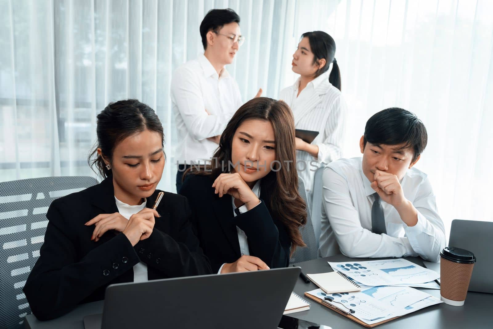 Harmony in office concept as business people analyzing dashboard paper together in workplace. Young colleagues give ideas at manager desk for discussion or strategy planning about project.