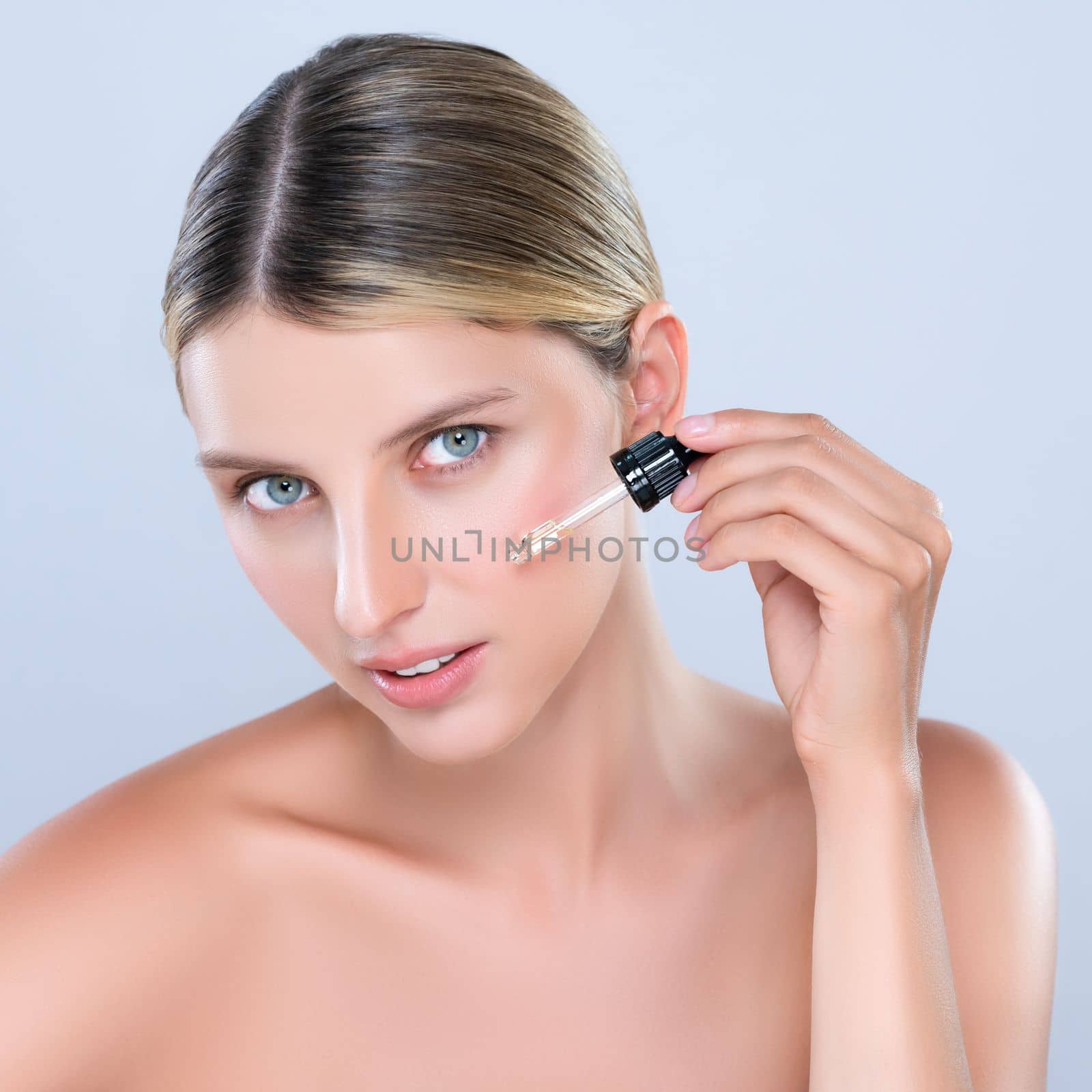 Alluring portrait of beautiful woman in isolated applying extracted cannabis oil bottle for skincare product. Cannabis and CBD oil for facial treatment cosmetology and beauty concept.