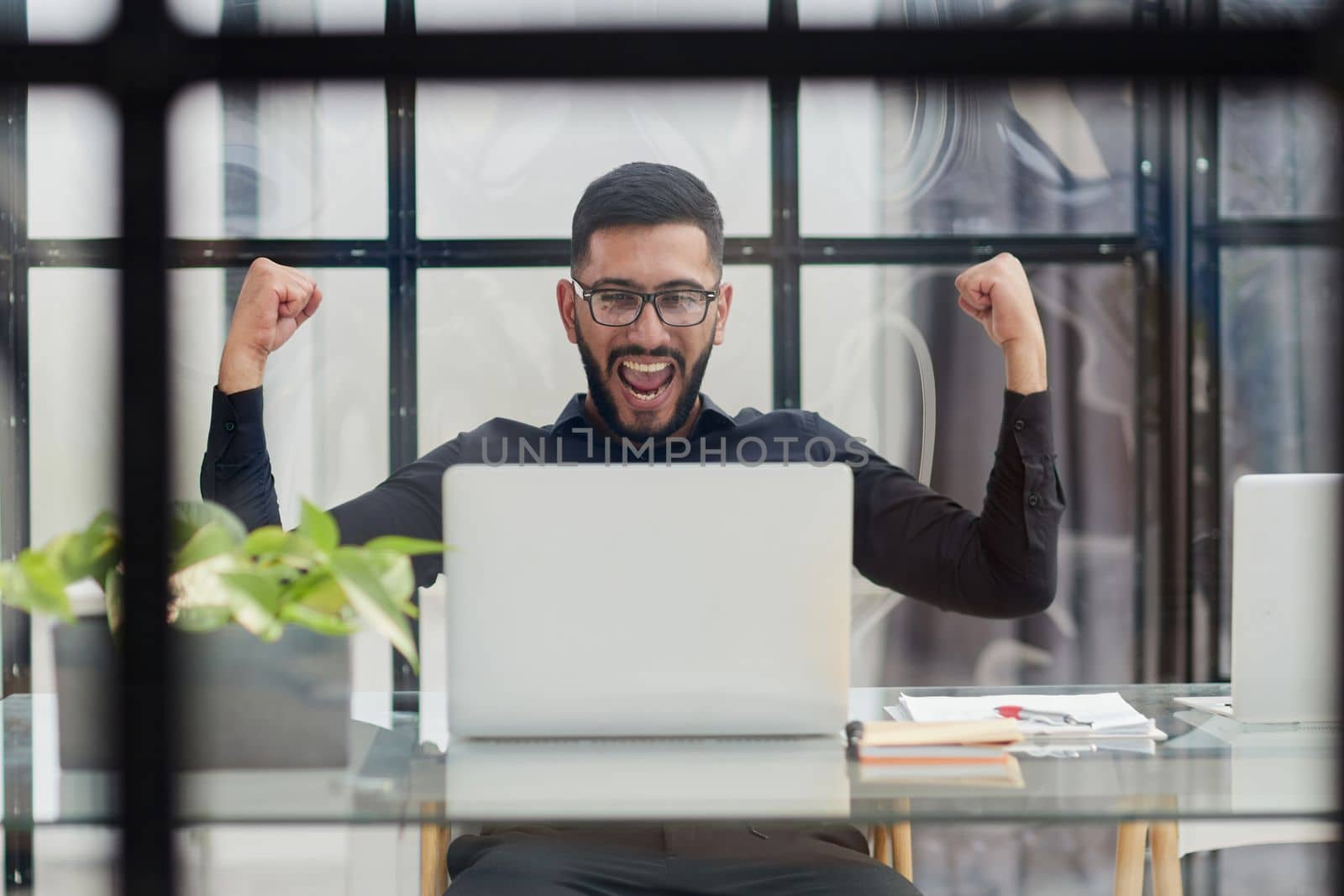 Business man sitting at his desk in the office with a laptop