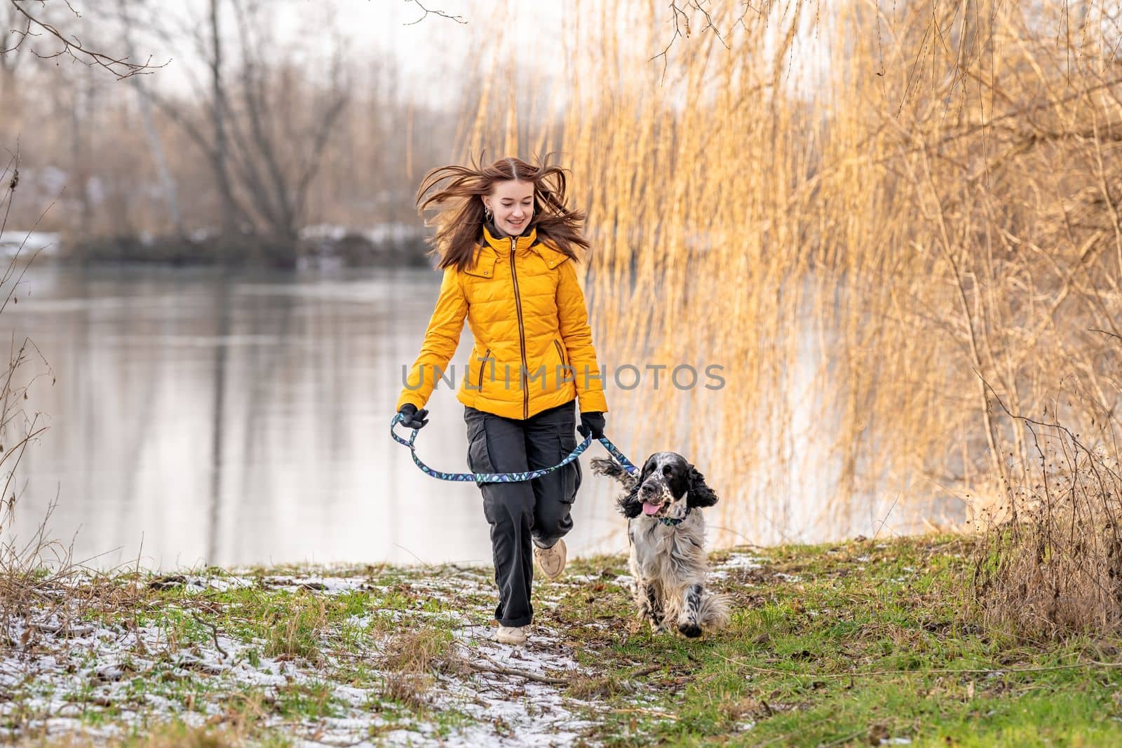 teenager with a dog on a walk in the park next to the lake. english setter by Edophoto