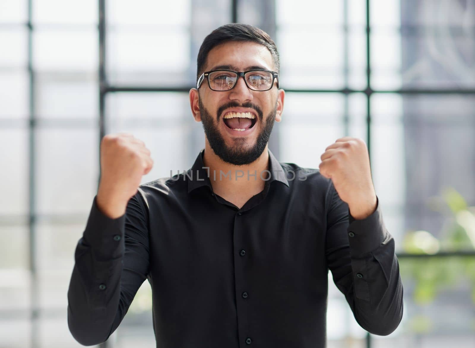Businessman in stadium crowd, punching air, low angle view