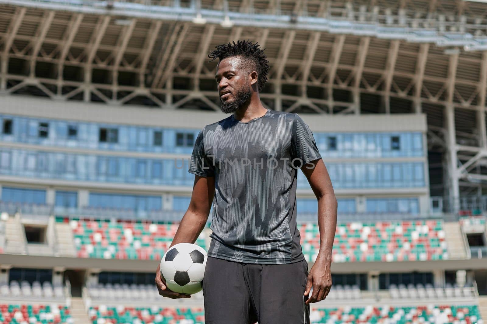confident black football player holding the ball in his hand
