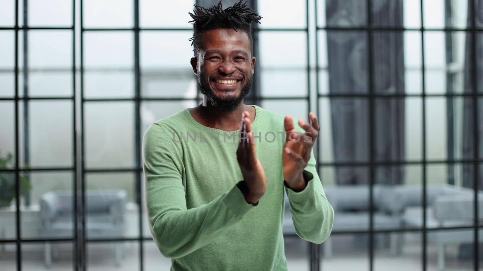 footage of a happy young businessman clapping in a modern office.