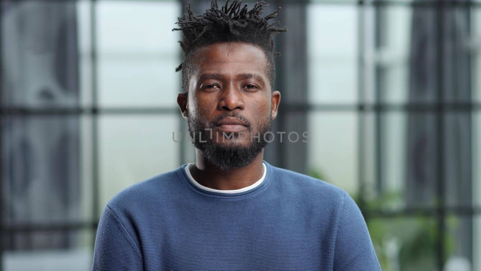 Handsome charming cheerful african american businessman in chic colorful casual clothes, in an office building
