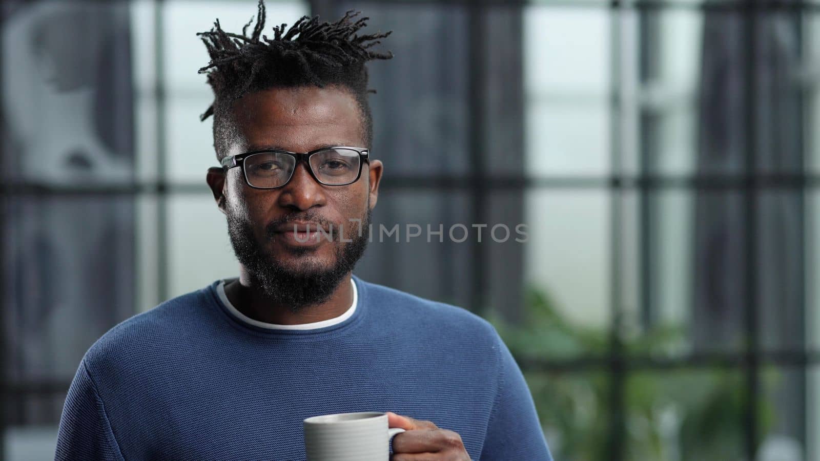 Portrait of a smiling CEO at workplace in a modern office in casual wear with glasses