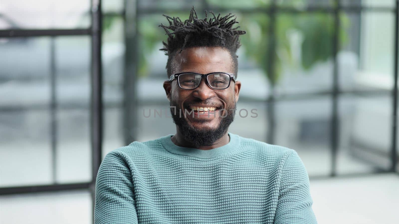 African American man in green sweater looking at camera