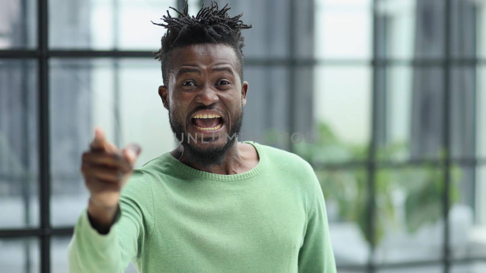 Handsome businessman pointing his finger to the camera and slicking virtual image or text. Young african american guy