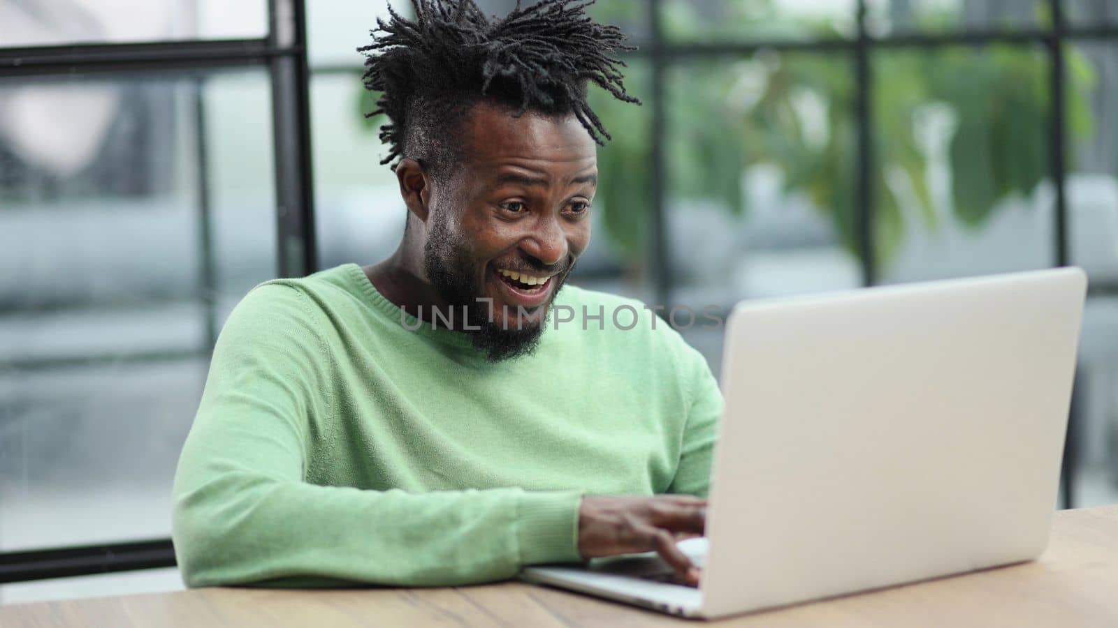 Close-up of a laughing african american man looking into a laptop