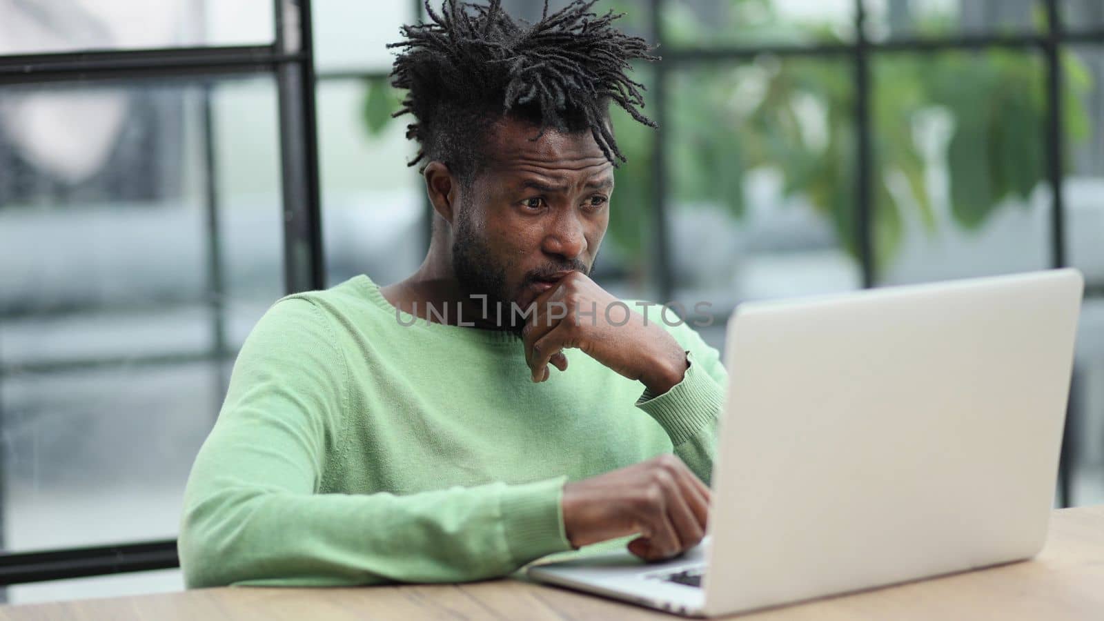 Close-up of a laughing african american man looking into a laptop