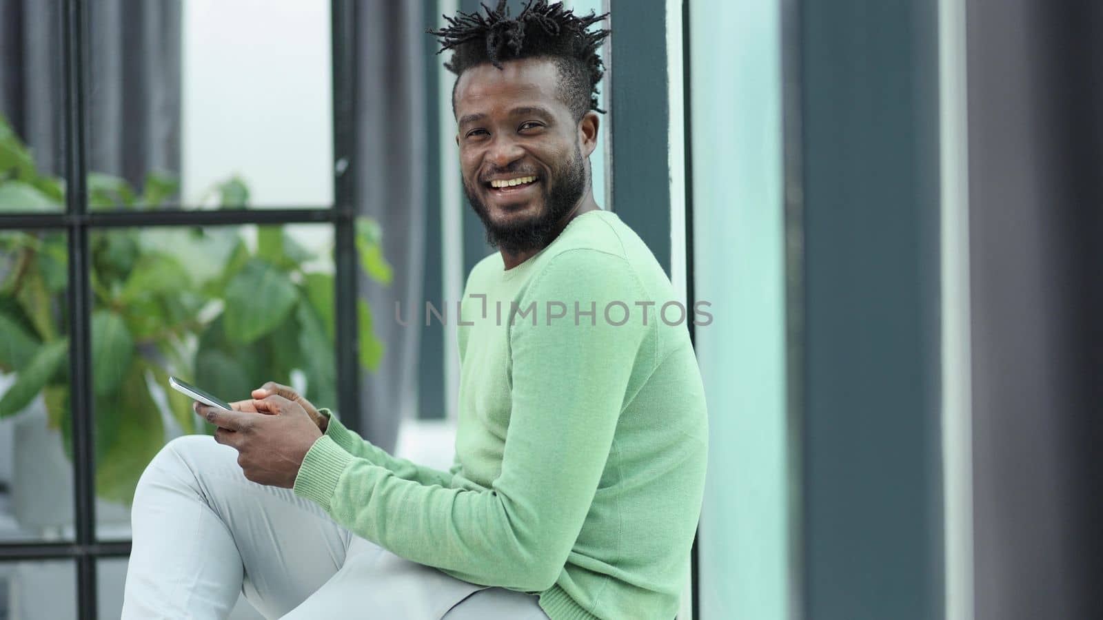 Smiling young adult african american hipster business man professional making business call talking on the phone