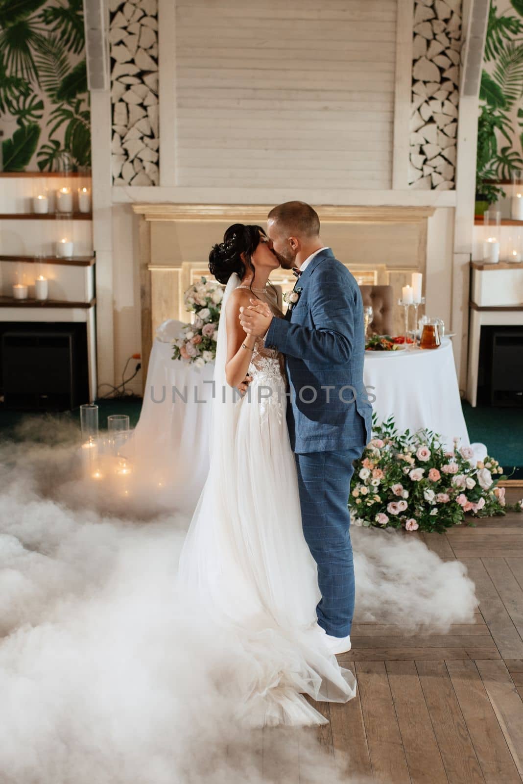 the first dance of the bride and groom inside a restaurant with heavy smoke
