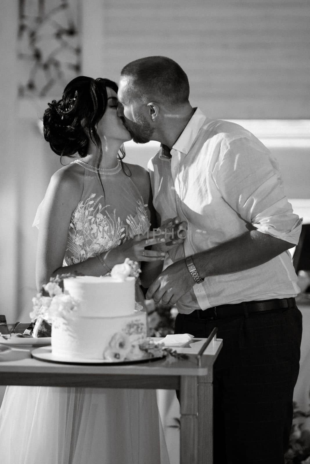 newlyweds happily cut and taste the wedding cake by Andreua