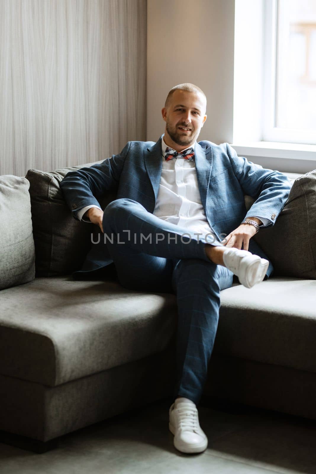 portrait of smiling groom with beard in blue color suit