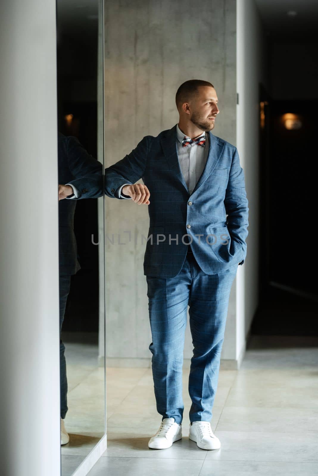 portrait of smiling groom with beard in blue color suit