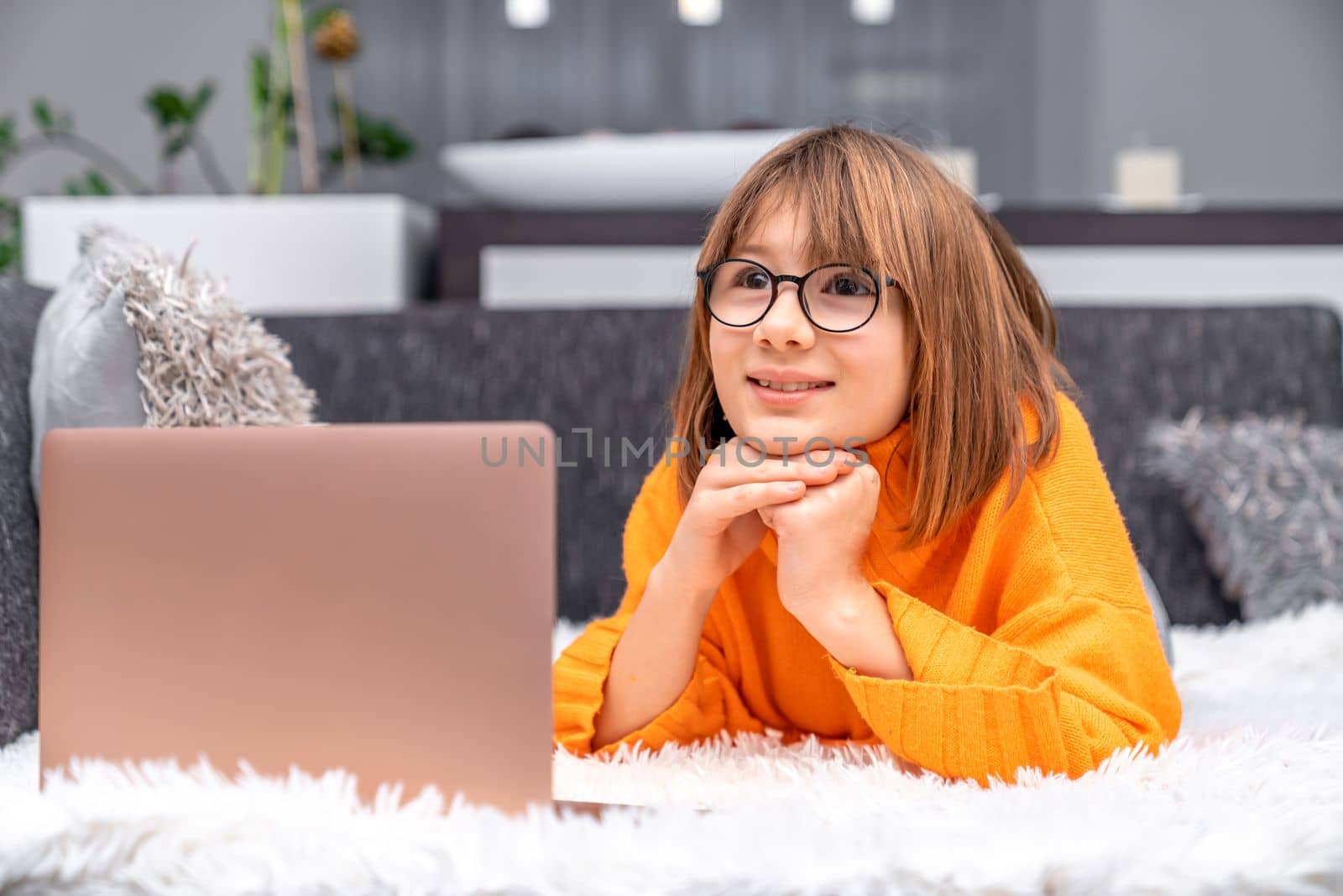 child uses a laptop at home for online learning and entertainment. High quality photo