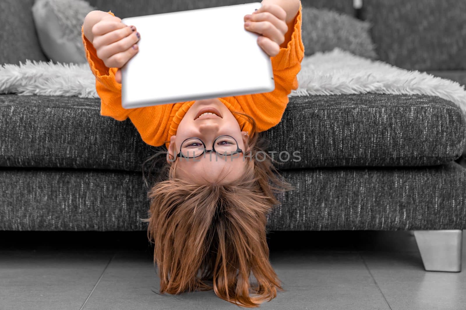 the child uses a tablet at home to learn and communicate online. High quality photo