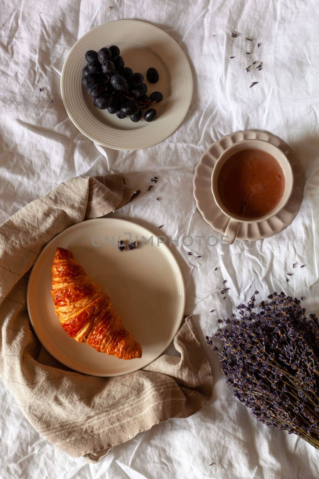 traditional french breakfast of a croissant, grapes and hot chocolate, overhead photo