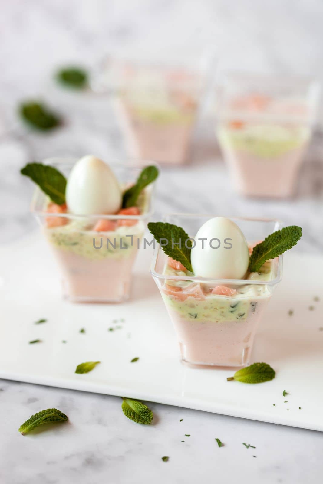 mini portions of salmon and cream mousse decorated with mint leaves, chick imitation, Easter appetizer