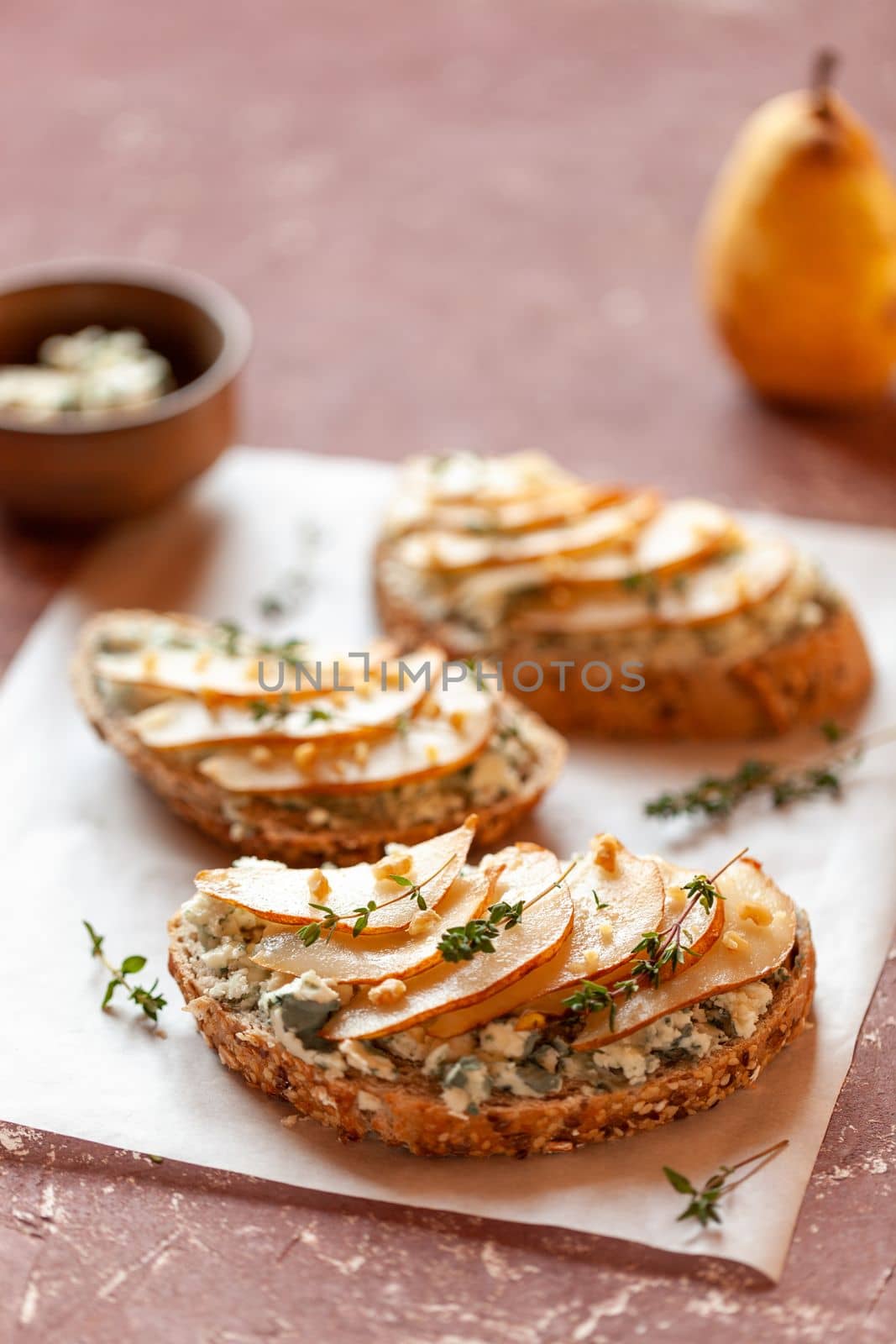 Roquefort french cheese and sliced peaches toasts on a square plate by lanych