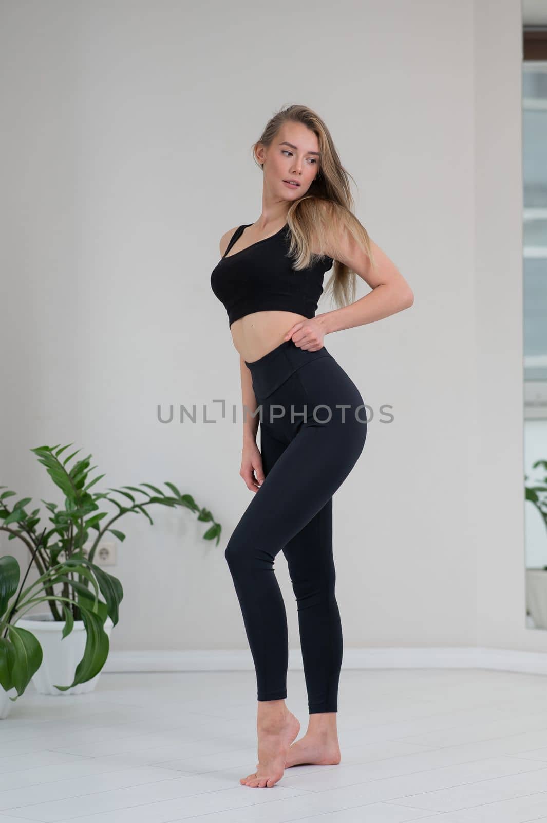 Full length portrait of a beautiful caucasian woman in black sportswear