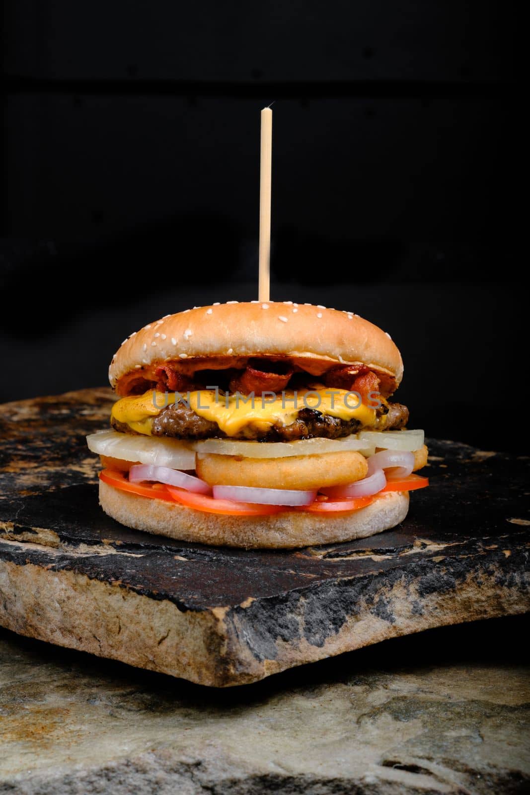 Rustic tasty Burger on Stone Background dark