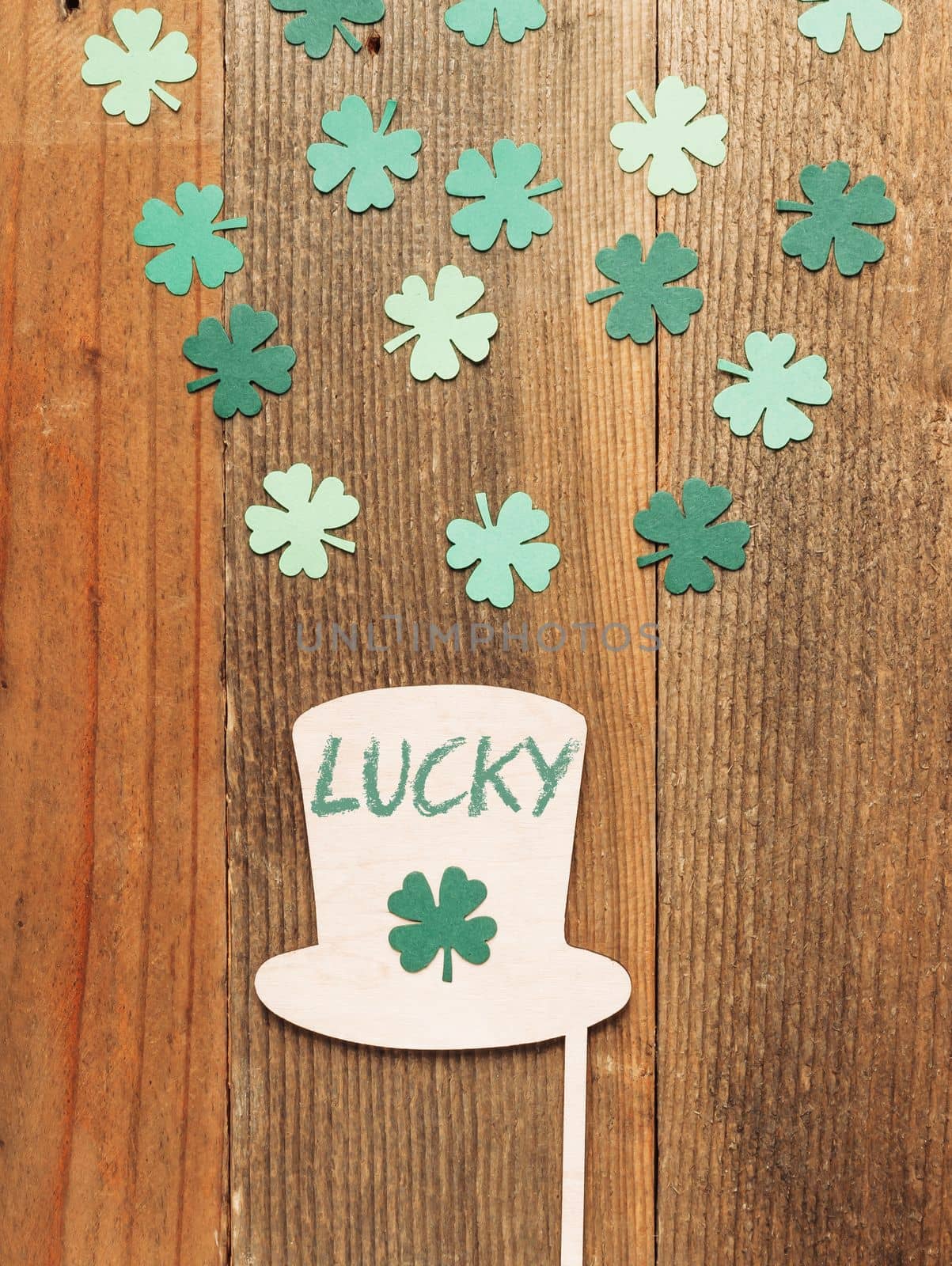 Flat lay with hat and clover on wooden table with lucky lettering. High quality photo