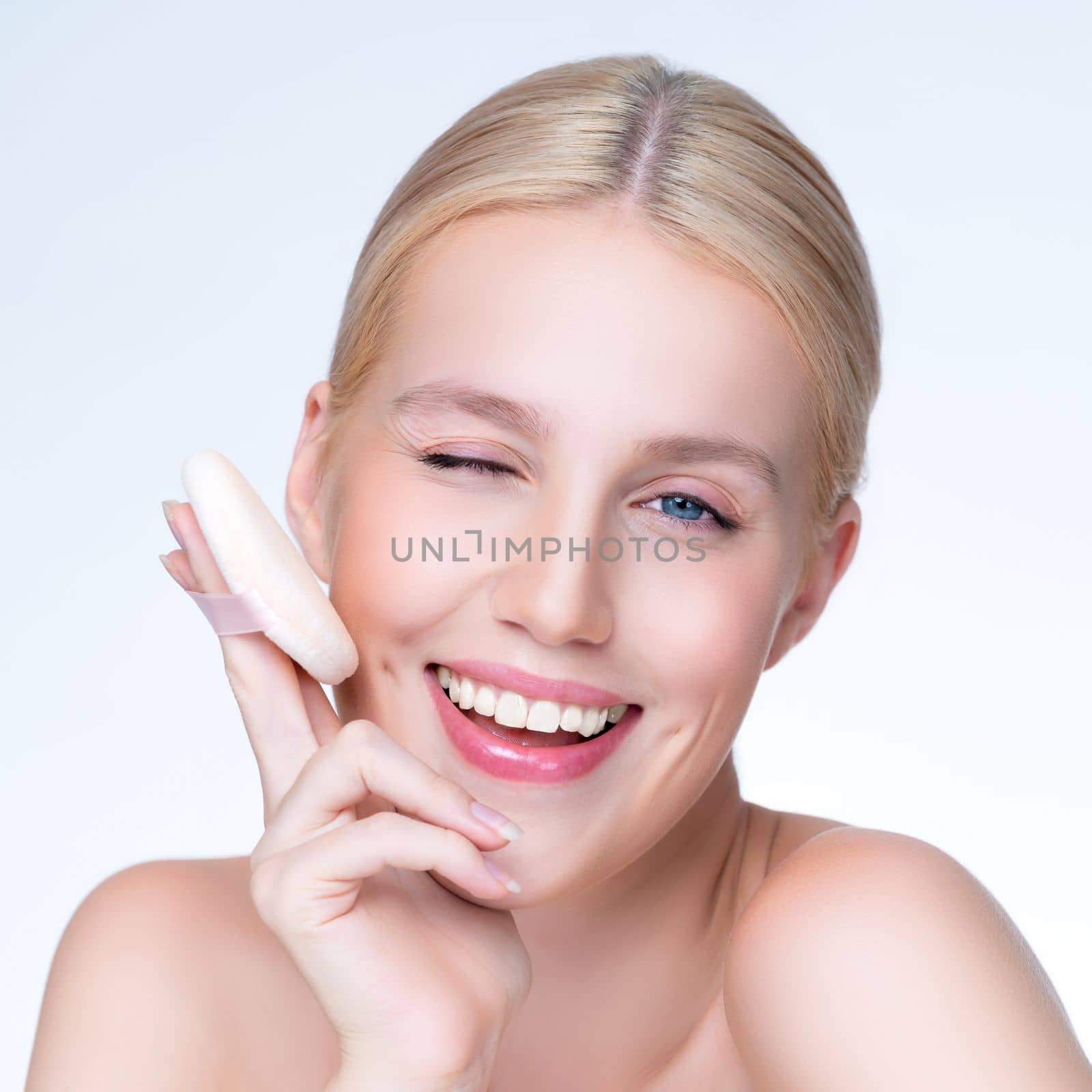 Closeup personable beautiful natural soft makeup woman using powder puff for facial makeup concept. Cushion foundation applying on young girl face in isolated background.