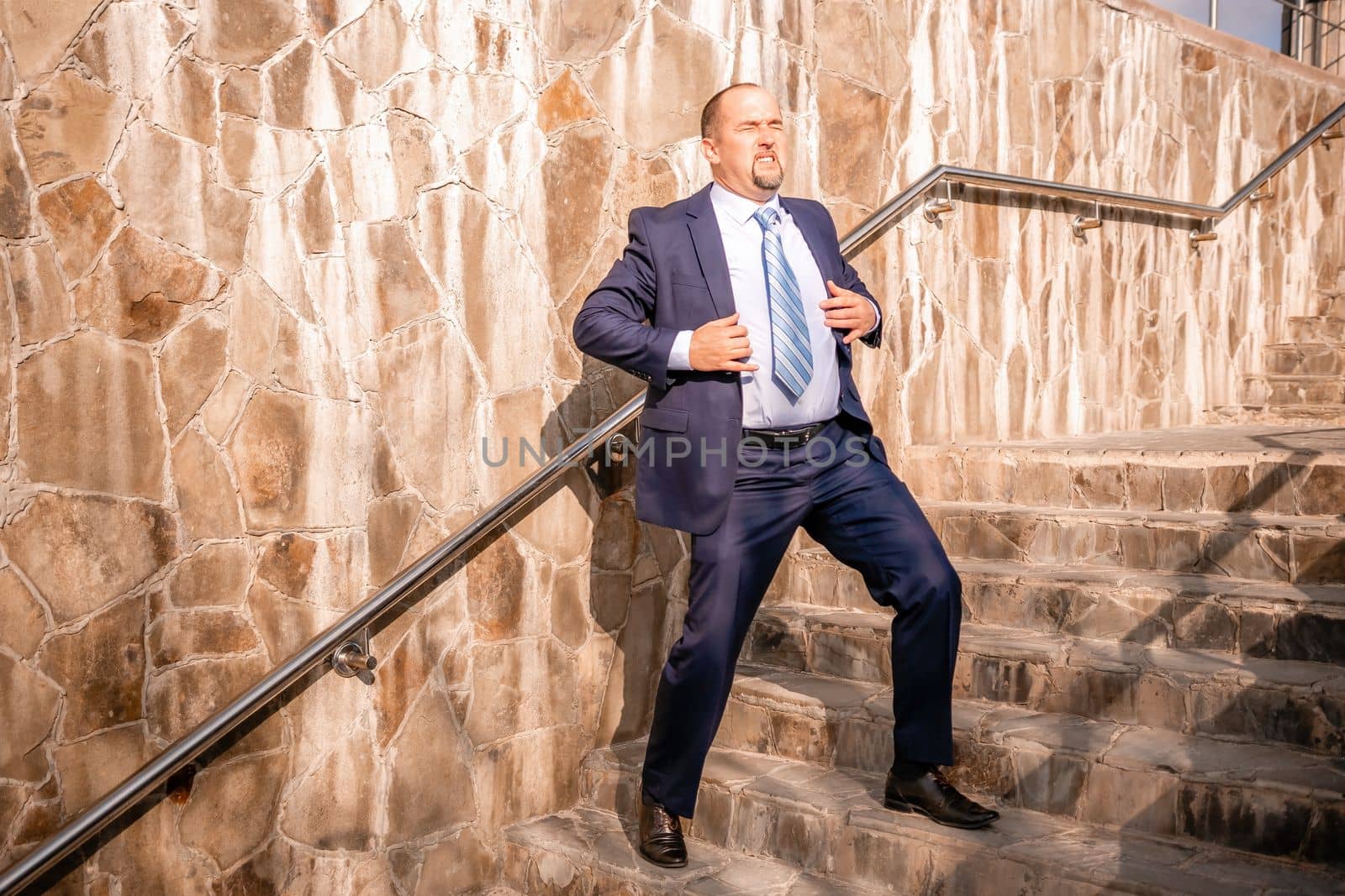Portrait of a senior professional man in a suit with various problems. A middle-aged businessman with a briefcase descends the stairs.