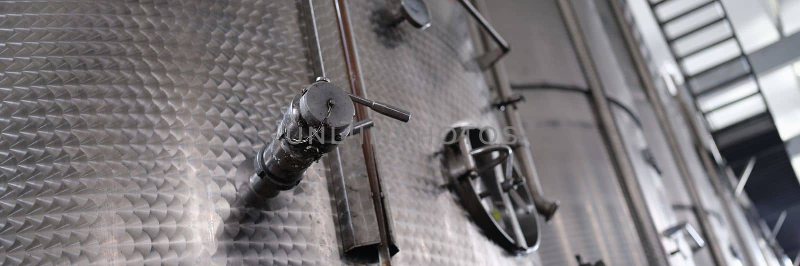 Modern wine distillery and brewery with brew kettles pipes and stainless steel tanks. Production equipment of chemical and pharmaceutical industries