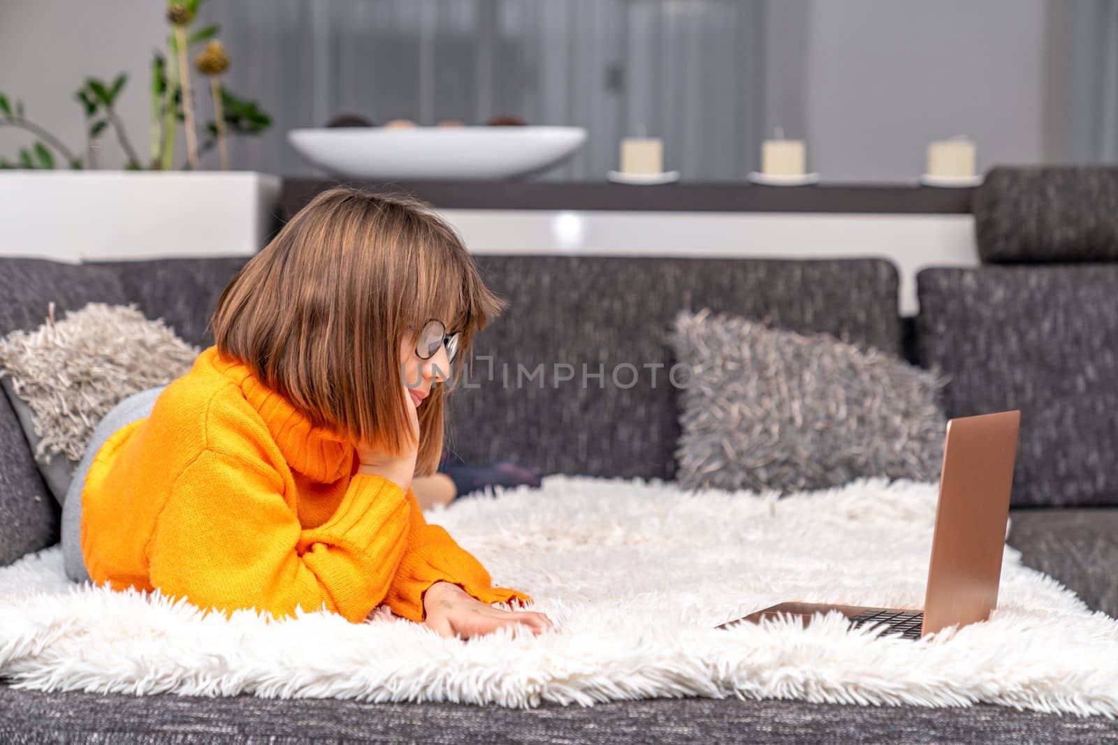 child with a laptop on the couch, home online learning by Edophoto