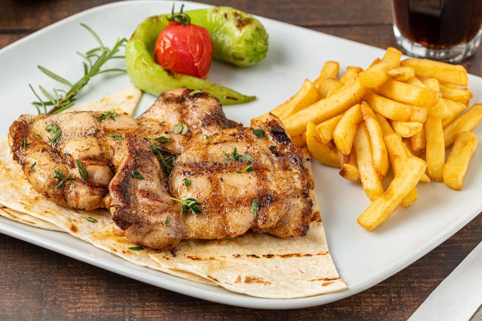 Spicy grilled chicken on a white porcelain plate