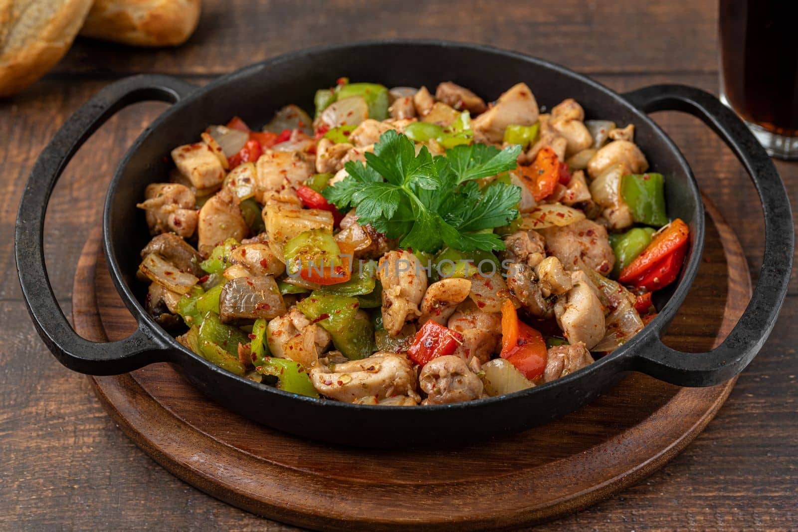 Sauteed chicken with pepper in a cast iron pan