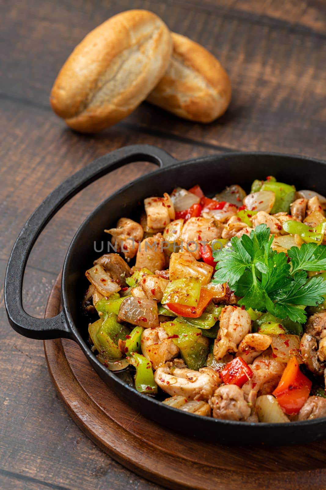 Sauteed chicken with pepper in a cast iron pan