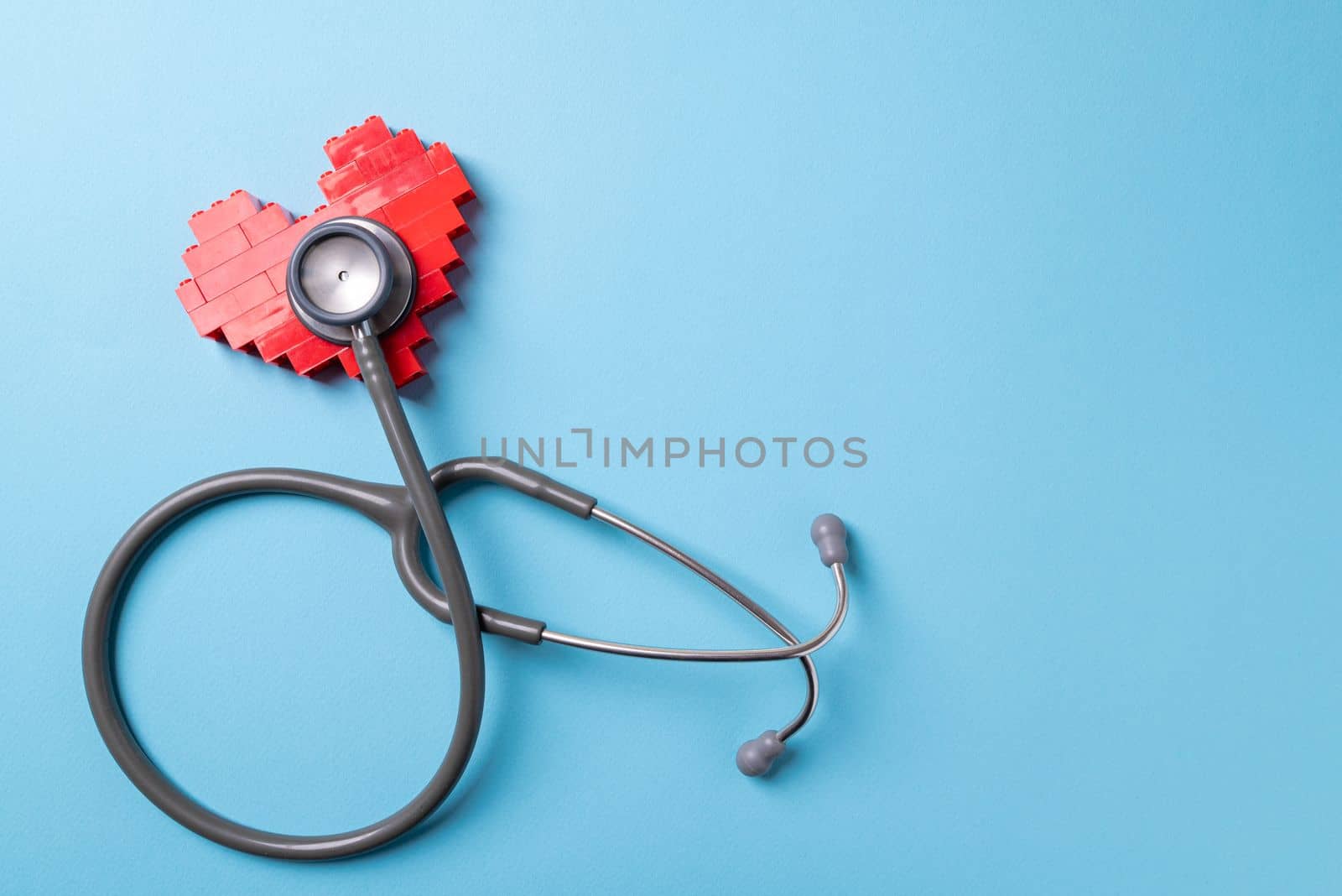 stethoscope standing on red heart on blue background